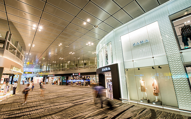 The transit area of Changi Airport with shops including Zara